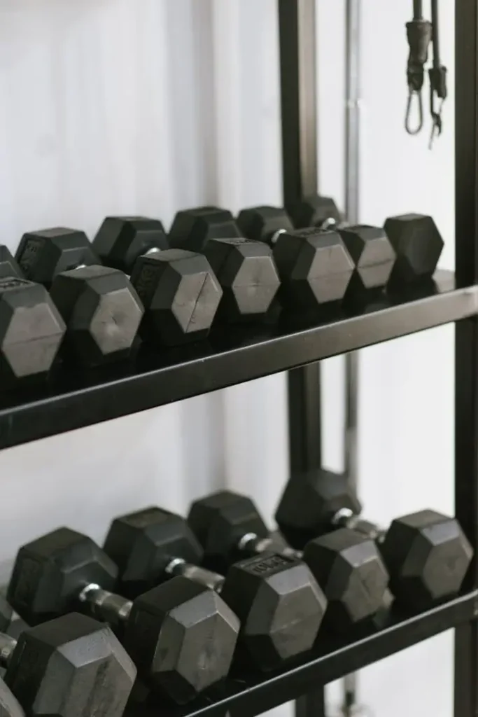 pexels-photo-16513605-16513605 Organized hexagonal dumbbells stacked on a sturdy rack in a modern gym setting.