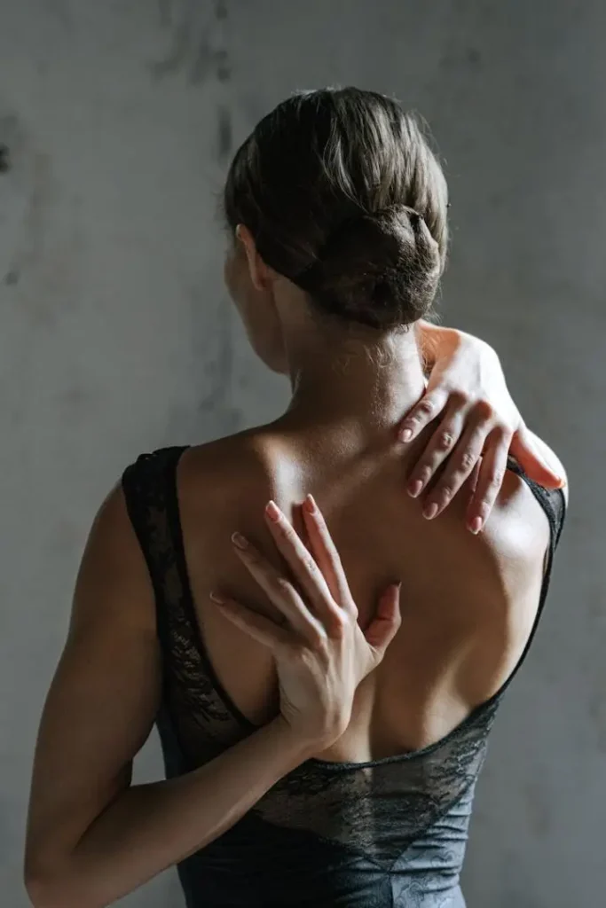 pexels-photo-5255007-5255007 Back view of a woman stretching with hands behind her back in a black tank top